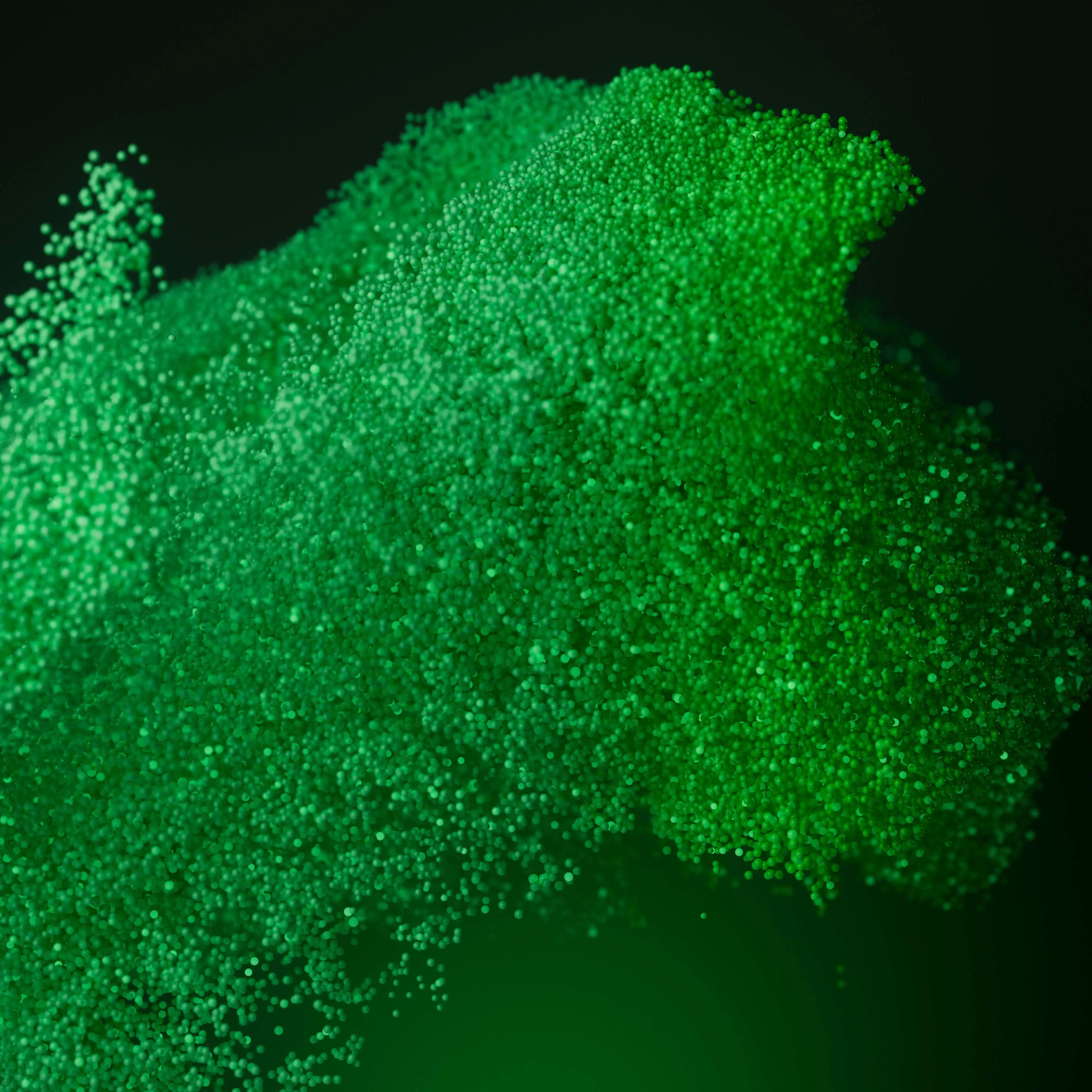 Abstract green particles forming a flowing wave on a dark background